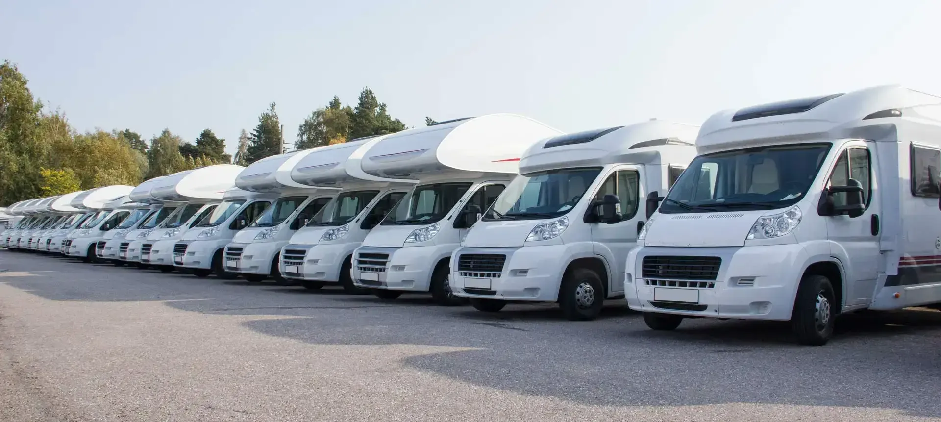 Mehrere Wohnmobile in einer Reihe auf dem Firmengelände – Fahrzeugbestand für Bewertung und Ankauf