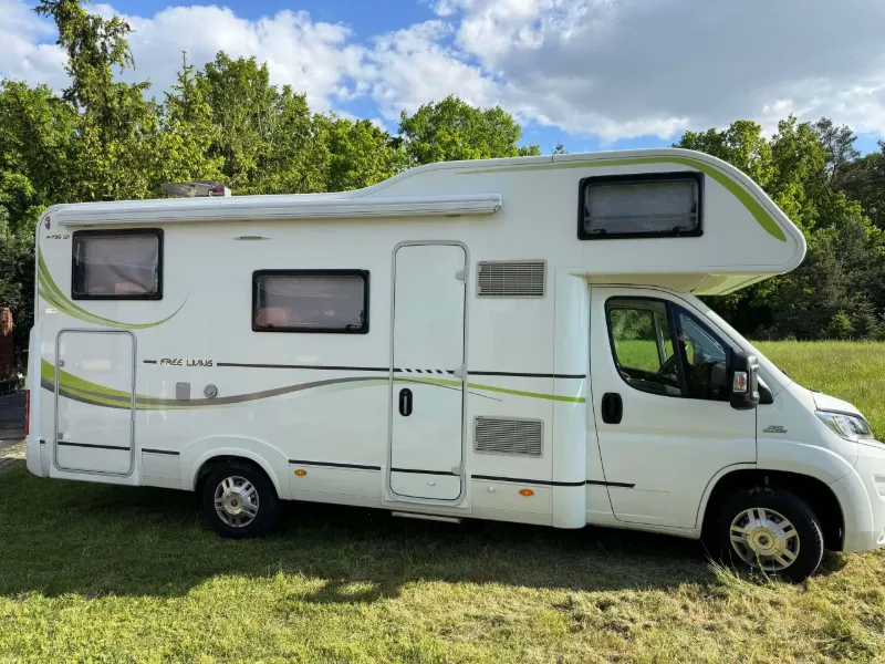 Weißes Alkoven-Wohnmobil auf einer Wiese – typisches Fahrzeug für Ankauf und faire Bewertung